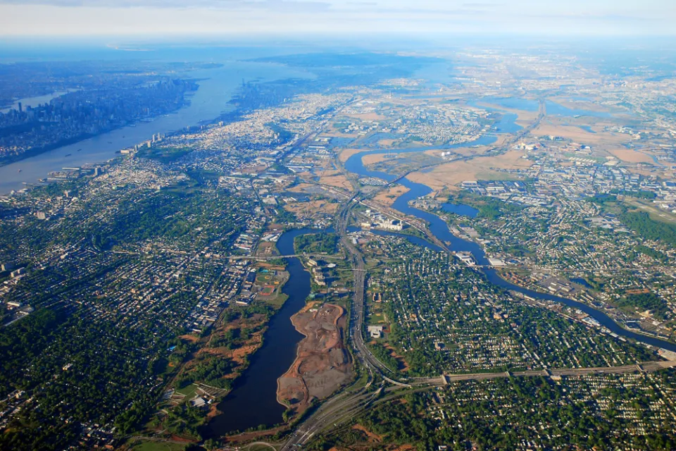 An aerial view of New Jersey suburbs, with Manhattan and New York City in the distant background.